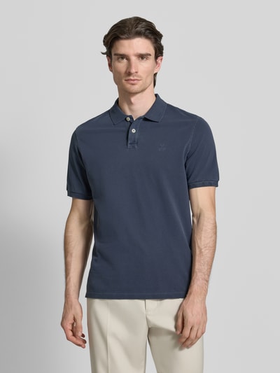 Männermodel trägt Poloshirt aus Baumwolle von MARC O’POLO DENIM in Dunkelblau, gerader Schnitt, Piqué, Logo, Nahaufnahme Oberkörper.