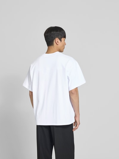 Männermodel trägt Relaxed Fit T-Shirt mit Logo-Stitching von WON HUNDRED, reine Baumwolle, weiß, Kurzarm, Rückenlänge 70 cm, Ganzkörperansicht Rückansicht.