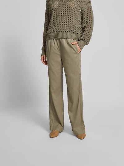 Frauenmodel trägt Stoffhose mit Lyocell-Anteil von Juvia, Farbe Olivgrün, weiter Straight Fit, elastischer Bund, Eingrifftaschen, Nahaufnahme Oberkörper.