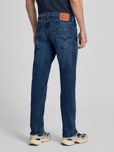 Männermodel trägt Tapered Fit Jeans aus Baumwoll-Lyocell-Mix Modell '502® TAPER' von Levi's®, dunkelblau, Herren Jeans, Ganzkörperansicht Rückansicht.