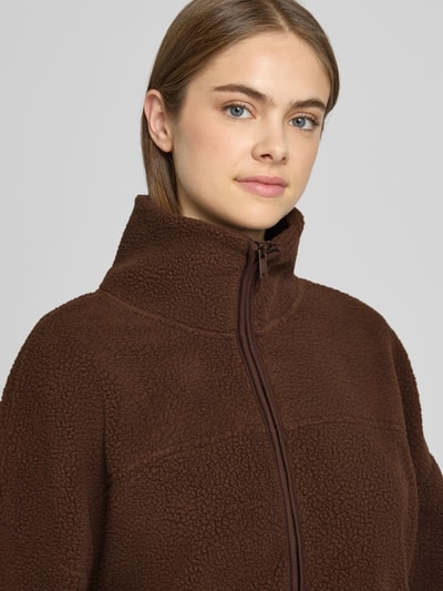 Vrouwenmodel draagt Fleecejacke mit Reißverschluss Modell 'COZY' van NOISY MAY®, bruin teddyfleece, relaxed fit, detailopname bovenlichaam.