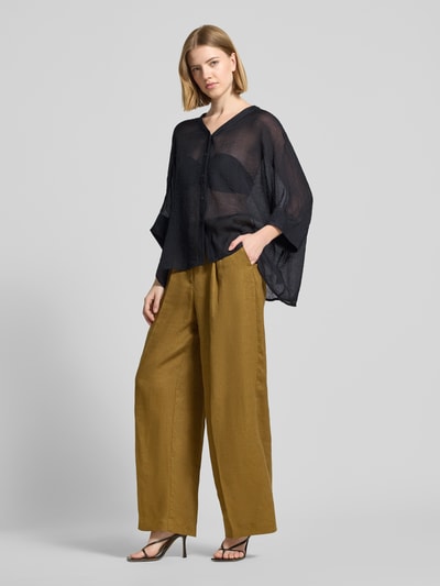 Frauenmodel trägt Relaxed Fit Bluse aus Viskose-Mix mit V-Ausschnitt von Comma, Knopfleiste, 3/4-Arm, transparente schwarze Optik, Ganzkörperansicht von vorne.