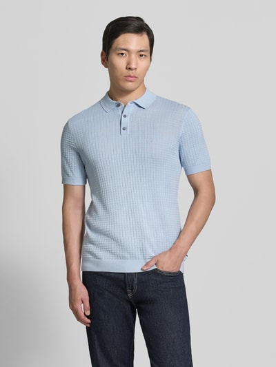 Männermodel trägt Slim Fit Poloshirt in Strick-Optik Modell 'Vanceo' von JOOP! Collection aus reiner Baumwolle, Ganzkörperansicht von vorne.