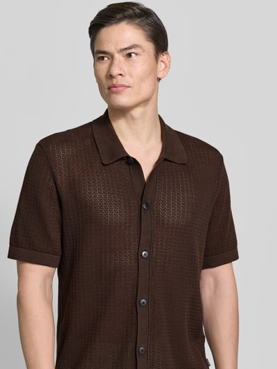 Männermodel trägt Regular Fit Freizeithemd in Strick-Optik Modell 'Owen' von Jack & Jones Premium, braun, Reine Baumwolle, Semitransparent, Kurzärmelig, Kentkragen, Knopfleiste, Nahaufnahme Oberkörper. Rückenlänge bei Größe M: 72 cm, Schulterbreite: 47 cm, Ärmellänge: 27 cm.