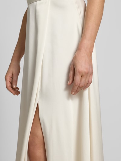 Frauenmodel trägt Relaxed Fit Abendkleid mit Gehschlitz von Jake*s Cocktail in Satin, cremefarben, glatte Textur, Nahaufnahme Oberkörper.