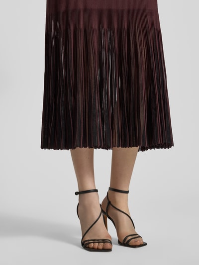 Kobieta nosi Strickkleid aus Rippstrick od BOSS, kolor bordowy, transparentne plisowane fałdy, długość do kolan, detal dolnej części sukienki, zbliżenie na nogi