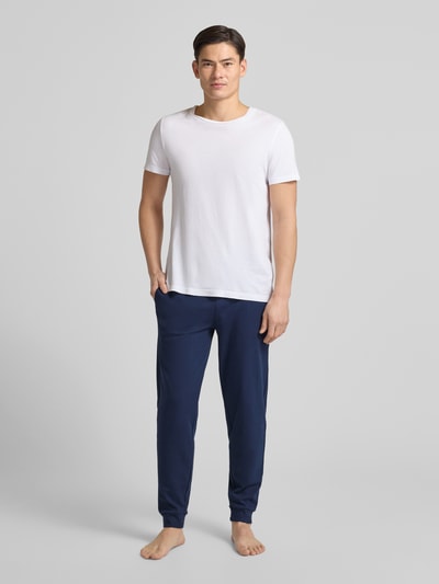 Männermodel trägt dunkelblaue Sweatpants mit elastischem Bund von Christian Berg Men, reine Baumwolle, gerade Passform, Ganzkörperansicht von vorne.