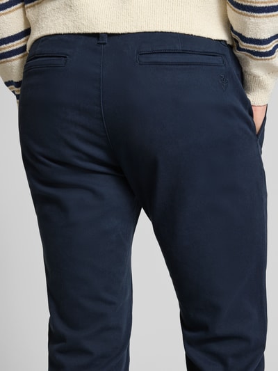 Männermodel trägt Schmale Chino mit gerader Silhouette und mittlerer Bundhöhe von REVIEW in Dunkelblau, Baumwoll-Elasthan-Mix, Ganzkörperansicht Rückansicht.