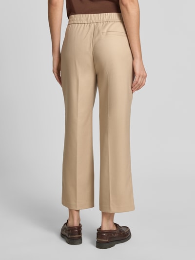 Frauenmodel trägt Stoffhose mit Bügelfalte Modell 'Melane' von OPUS, Material-Mix mit Viskose-Anteil, Straight Fit, Gesäßleistentasche, beige, Ganzkörperansicht Rückansicht.