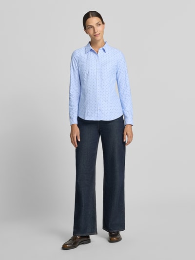 Vrouwenmodel draagt lichtblauwe 'Hemdbluse aus reiner Baumwolle' van Christian Berg Woman met stippenprint, getailleerde pasvorm, overhemdkraag, met lange mouwen, ruglengte bij maat 36: 66 cm, mouwlengte bij maat 36: 61 cm, puur katoen, effen structuur, volledig lichaam aanzicht van voren.