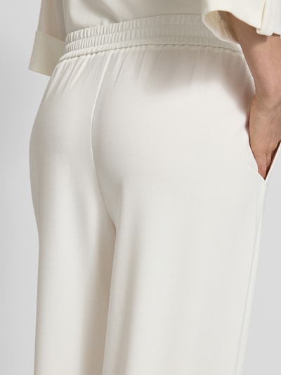 Frauenmodel trägt Regular Fit Weite HOSE mit Viskose-Anteil von s.Oliver BLACK LABEL, Optik: Unifarben, seitliche Eingrifftaschen, elastischer Bund, Material-Mix, Detailaufnahme Rückansicht.