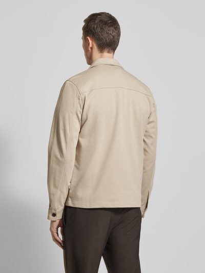 Männermodel trägt Relaxed Fit Hemdjacke mit Brusttasche von Lindbergh in Beige, Material-Mix mit Viskose-Anteil, Ganzkörperansicht Rückansicht.