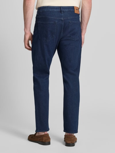 Männermodel trägt Straight Leg Jeans im 5-Pocket-Design Modell 'Ray' von JOOP! Jeans, dunkelblau, Baumwoll-Mix, Ganzkörperansicht Rückansicht.