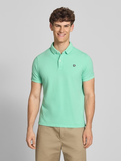 Männermodel trägt Regular Fit Poloshirt mit Logo-Stitching von Superdry aus Reine Baumwolle, Polokragen, Kurzärmelig, Ganzkörperansicht von vorne.