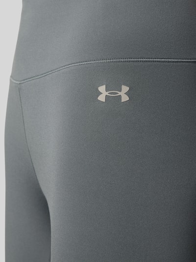 Frauenmodel trägt Slim Fit Leggins mit semitransparenten Partien Modell 'Motion' von Under Armour im Elastischer-Material-Mix mit Logo-Print, Detailaufnahme.