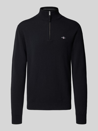 Produktfoto, Pullover aus reiner Wolle von GANT in Schwarz, Feinstrick, hochgeschlossener Troyer-Kragen, Reißverschluss, lange Ärmel.