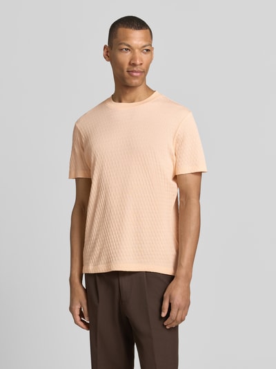 Männermodel trägt T-Shirt mit Strukturmuster Modell 'Raulos' von JOOP! Collection aus Reine Baumwolle, Modern Fit, Rundhalsausschnitt, Label-Detail, sanfte Beige- und Brauntöne, feine Struktur, Rückenlänge bei Größe M: 68 cm, Ganzkörperansicht von vorne.