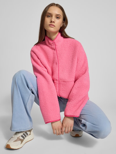 Frauenmodel trägt Relaxed Fit Fleecejacke mit Stehkragen Modell 'VERA' von JJXX, Teddyfell, Knopfleiste, Eingrifftaschen, Ganzkörperansicht von vorne. Rückenlänge 57 cm, Schulterbreite 41 cm, Brustweite 53 cm, Ärmellänge 54 cm, Farbe pink, strukturierte Oberfläche.