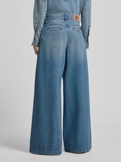 Männermodel trägt Wide Leg Jeans mit Falten Modell 'TOBY' von Bash aus bawełna, wpuszczane kieszenie, szerokość w rozmiarze 36: 37 cm, długość wewnętrzna nogawki w rozmiarze 36: 82 cm, jasnoniebieski denim, szerokie nogawki, model dwustronny, Ganzkörperansicht Rückansicht.