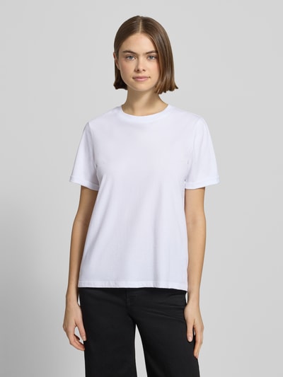 Frauenmodel trägt Regular Fit T-Shirt aus reiner Baumwolle Modell 'RIA' von Pieces, Optik: Unifarben, Feinripp, Label-Stitching-Applikation, Rundhals, Kurzarm mit fixiertem Umschlag, Ganzkörperansicht von vorne.