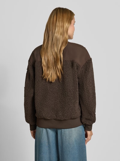 Frauenmodel trägt Teddyjacke mit Stehkragen Modell 'Emeline' von MOS MOSH in Braun mit strukturierter Oberfläche, lockerer Passform, Ganzkörperansicht Rückansicht. Damen Teddyjacke mit Reißverschlusstasche am Ärmel, Zweiwege-Reißverschluss, seitlichen Eingrifftaschen, Label-Detail und elastischen Abschlüssen.