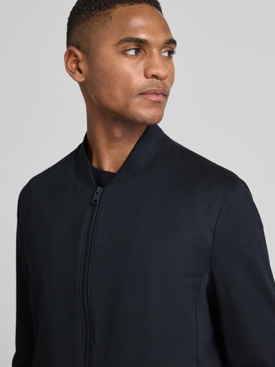 Męski model nosi Regular Fit Sweatjacke mit Viskose-Anteil Modell 'Cross' od CINQUE, ciemny kolor, gładka tekstura, zapięcie na zamek, stójka, widok z przodu, półzbliżenie górnej części ciała.