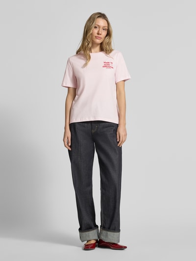 Frauenmodel trägt Regular Fit T-Shirt aus reiner Baumwolle Modell 'LUALAA EMBRO' von Armedangels, unifarben, Rundhals, Feinripp, Ganzkörperansicht von vorne.