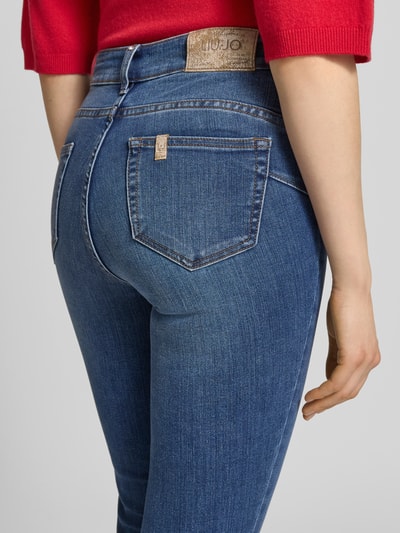 Frauenmodel trägt Skinny Fit Jeans Modell 'DIVINE' von Liu Jo White aus blauem Baumwoll-Mix mit Stretch-Anteil, Detailaufnahme Rückansicht.