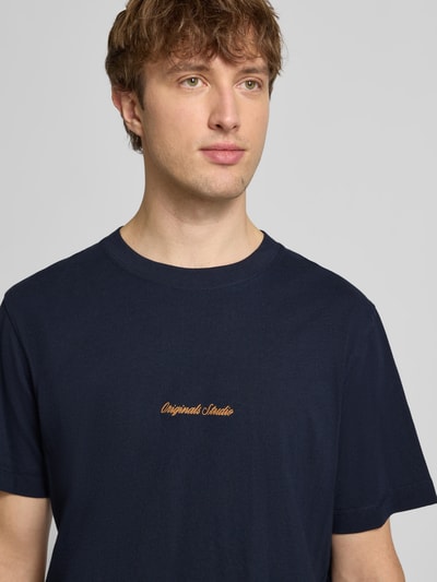 Männermodel trägt T-Shirt mit Label-Stitching Modell 'NORREBRO' von Jack & Jones in Dunkelblau, reine Baumwolle, Nahaufnahme Oberkörper.