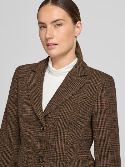 Kobiecy model nosi żakiet 'Blazer mit Reverskragen und Pattentaschen' od White Label, mieszanka materiałów z dodatkiem wełny lana, taliowany krój, kołnierz z połami, listwa guzikowa, kieszenie z patką, długość tyłu w rozmiarze 36: 57 cm, szerokość w rozmiarze 36: 45 cm, długość rękawów w rozmiarze 36: 63 cm, brązowy wzór kratki, tekstura tkaniny, zbliżenie na górną część ciała