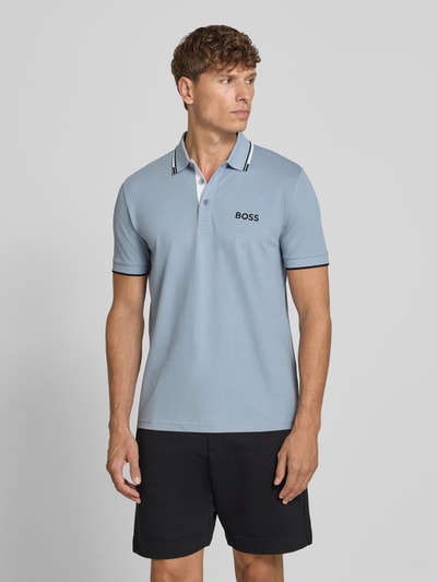 Männermodel trägt Regular Fit Poloshirt aus Baumwoll-Mix Modell 'PADDY PRO' von BOSS Green in Hellblau, Ganzkörperansicht von vorne.