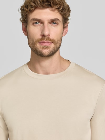 Männermodel trägt Regular Fit Longsleeve aus reiner Baumwolle Modell 'Pima' von RAGMAN in Beige, glatte Textur, Nahaufnahme Oberkörper. Rückenlänge bei Größe M 69 cm, Rundhalsausschnitt.