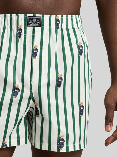 Męski model nosi Boxershorts aus reiner Baumwolle im 3er-Pack von Polo Ralph Lauren Underwear, biało-zielone paski, wzór w misie, zbliżenie na biodra