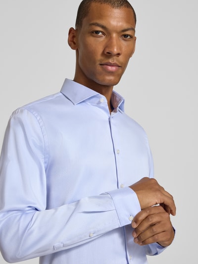 Männermodel trägt Slim Fit Businesshemd mit extra langem Arm von Jake*s in Hellblau, strukturierte Oberfläche, Nahaufnahme Oberkörper.