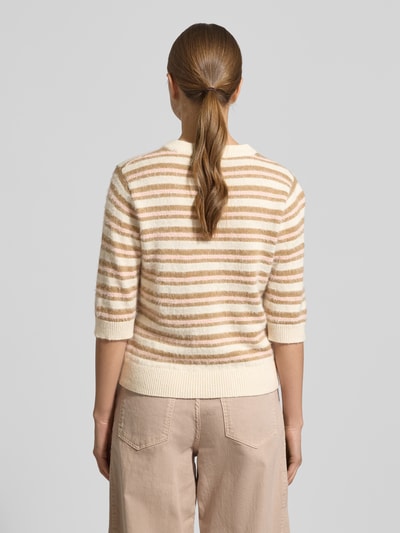 Frauenmodel trägt Strickpullover mit gerippten Abschlüssen von OPUS, Baumwoll-Mix, Slim-Fit, beige-weiß gestreift, Ganzkörperansicht Rückansicht.
