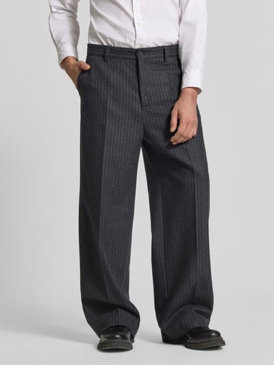 Męski model nosi Relaxed Fit Stoffhose aus Baumwoll-Mix von Filippa K, szare z białymi prążkami, kieszenie z przodu i z tyłu, bawełniany materiał, z zapięciem na guzik i suwak, szerokość w rozmiarze 50: 45 cm, długość wewnętrzna nogawki: 80 cm, widok całej sylwetki z przodu.