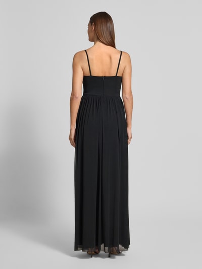 Modelka kobieta ma na sobie wieczorową sukienkę z cienkimi ramiączkami od TROYDEN COLLECTION, czarna, mesh, krój taliowany, maxi, marszczenia, z tyłu zamek, długość tyłu w rozmiarze 36: 137 cm, szerokość w rozmiarze 36: 36 cm, pełny widok sylwetki z tyłu.