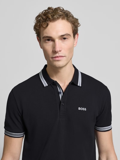 Männermodel trägt Regular Fit Poloshirt mit Label-Stitching Modell 'Paddy' von BOSS aus reiner Baumwolle, Nahaufnahme Oberkörper.