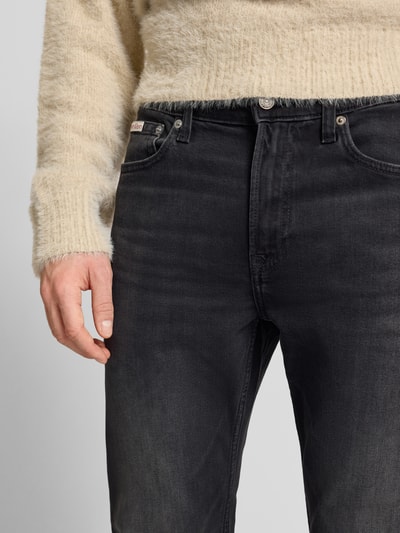 Männermodel trägt Jeans mit 5-Pocket-Design von Calvin Klein Jeans, Slim Fit, schwarzer Baumwoll-Elasthan-Mix, Nahaufnahme Oberkörper.