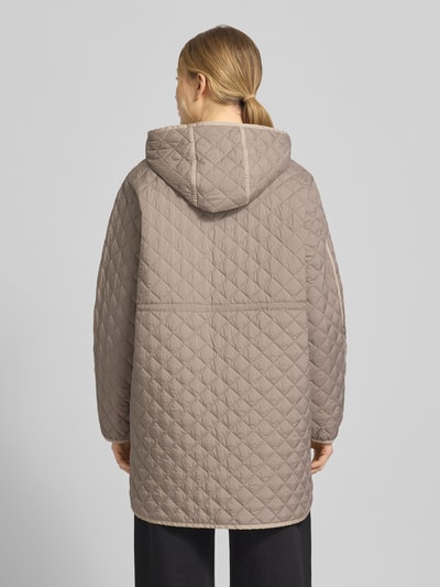 Modelka nosi Steppmantel mit Druckknopfleiste od WHITE LABEL, luźny krój, kaptur, naszywane kieszenie, beżowy, całkowita długość z tyłu 74 cm, szerokość ramion w rozmiarze 36: 46 cm, szerokość w biuście w rozmiarze 36: 55 cm, długość rękawa w rozmiarze 36: 61 cm, widok całej sylwetki z tyłu