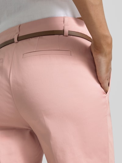Frauenmodel trägt Hose in verkürzter Passform mit Gürtel von Christian Berg Woman aus Baumwoll-Viskose-Mix in Rosé, Detailaufnahme Rückansicht.