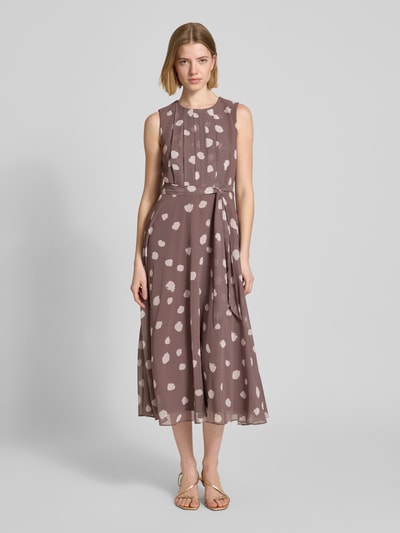 Vrouwenmodel draagt Midikleid mit gelegten Falten van Christian Berg Cocktail, taupe met witte vlekken, taillering, afneembare stoffen riem, ronde hals, mouwloos, ondoorzichtig onderjurk, geheel aanzicht van voren.