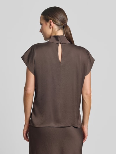 Frauenmodel trägt Blusentop mit Stehkragen Modell 'ALARIA' von DRYKORN in Braun, glatte Oberfläche, Knopfverschluss am Rücken, Ganzkörperansicht Rückansicht, Material-Mix mit Stretch-Anteil, Regular Fit, Rückenlänge bei Größe 36: 57 cm.