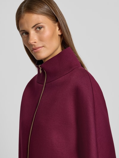 Frauenmodel trägt Jacke aus Viskose-Mix mit Stehkragen von Rinascimento in dunklem Beere, sichtbarer Reißverschluss, lockere Passform, Nahaufnahme Oberkörper.