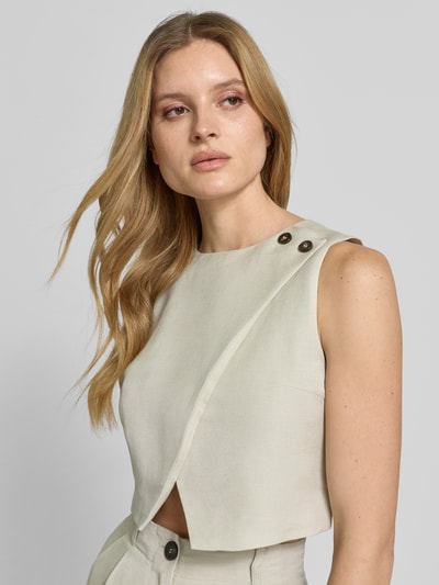 Frauenmodel trägt Cropped Bluse mit Knopfverschluss von Style Icon Collection aus reiner Baumwolle in hellem Beige, gerader Schnitt, Nahaufnahme Oberkörper.