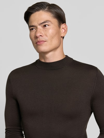 Männermodel trägt Slim Fit Longsleeve aus reiner Schurwolle Modell 'Arwon' von DRYKORN in Dunkelbraun, feine Struktur, Nahaufnahme Oberkörper. Rückenlänge 67 cm, Ärmellänge 68 cm, Stehkragen.