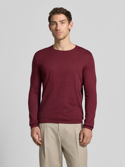 Männermodel trägt Strickpullover aus Baumwolle mit Rundhalsausschnitt von Christian Berg Men in Weinrot, glatte Struktur, Ganzkörperansicht von vorne. Slim Fit, Rückenlänge 68 cm, Ärmellänge 69 cm.