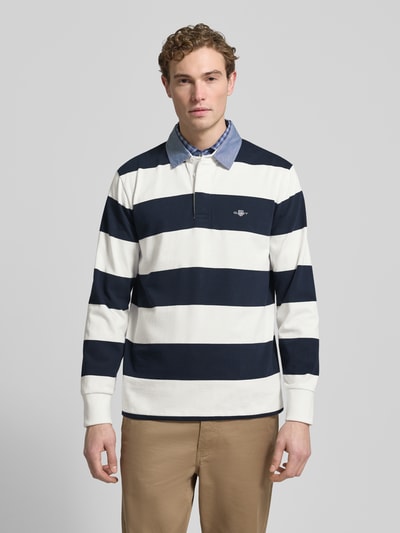 Männermodel trägt Sweatshirt mit Label-Stitching von Gant, Baumwolle, Regular Fit, Polokragen, marineblau-weiß gestreift, Ganzkörperansicht von vorne.