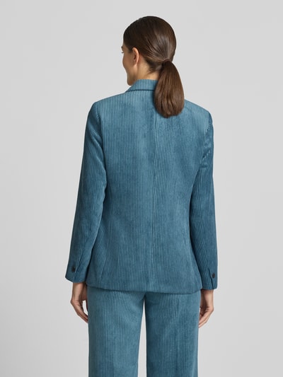 Frauenmodel trägt Slim Fit Blazer aus Cord mit Pattentaschen von COMMA in Blau, feine Rippenstruktur, Ganzkörperansicht Rückansicht.