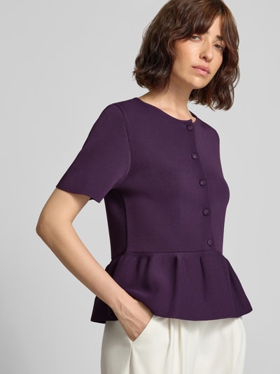 Frauenmodel trägt Cardigan aus Viskose-Mix mit Schößchen von Rich & Royal in dunklem Lila, taillierter Schnitt, Nahaufnahme Oberkörper.